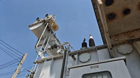 Low angle view looking up at large high voltage power transformer. Stock Photos