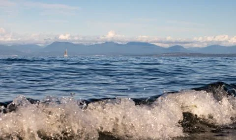 A low angle view looking out to sea on a sunny day, waves crashing Stock Photos