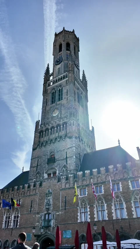 Low-angle view of the majestic Belfry tower in Bruges with flags. Vídeos de archivo 333196956