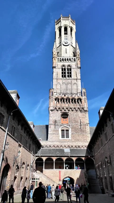 Low-angle view of the majestic Belfry tower in Bruges with flags. Vidéo 333197991