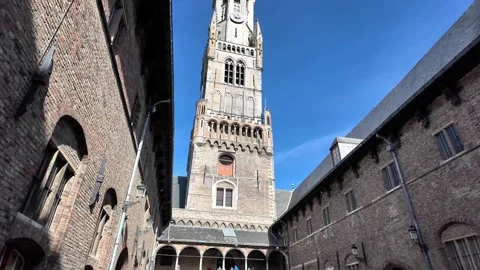 Low-angle view of the majestic Belfry tower in Bruges with flags. Vídeos de archivo 333197993