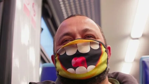 Low angle view of man face. He is in train and wearing a funny mask Stock Footage 147725967