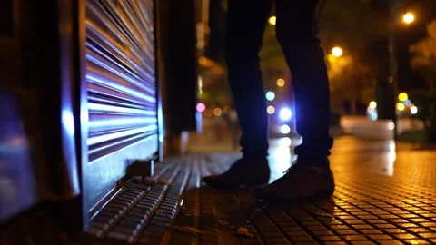 Low angle view, man getting closer and raising the shop shutter at early morning 스톡 동영상 244499068