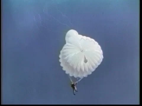 Low angle view of man parachuting against sky, 1970s Video stock 260258454
