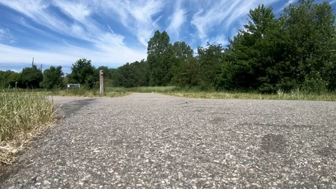 Low angle view of man riding racing bicycle fast on country road Stock Footage 98256275