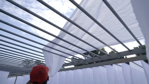 Low angle view of Man Spreading white material sheet of fabric cloth outside Stock-Footage 108798790