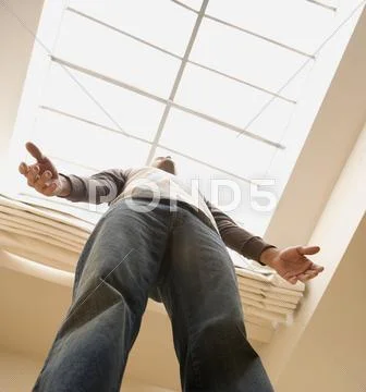 Low angle view of man standing under skylight Stock Photos