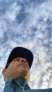 Low angle view of man standing against cloudy sky on sunny day Stock-Fotos