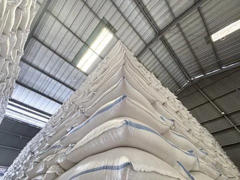 Low Angle View of Massive Stacks of White Sacks in Industrial Warehouse Foto stock