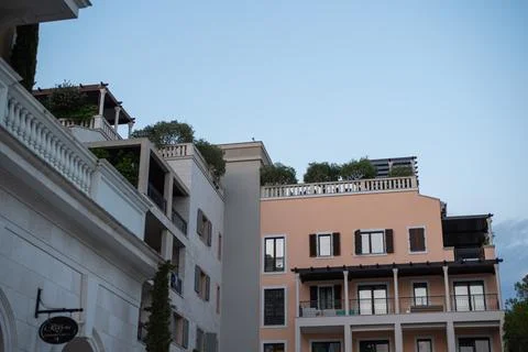 Low-angle view of Mediterranean buildings with balconies and rooftop gardens Stock Photos