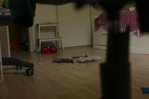 Low angle view of messy bedroom floor with toys and stool Stock Photos