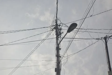 Low angle view of messy cables connected through a power pole Stock Photos