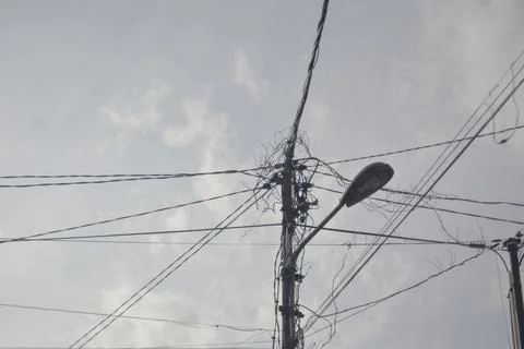 Low angle view of messy cables connected through a power pole Stock Photos