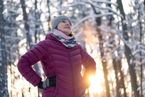 Low angle view of middle aged caucasian woman enjoying  winter time in forest Stock Photos