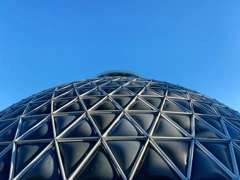 Low angle view of the modern abstract building under the clear sky ion a sunny d Fotos de archivo
