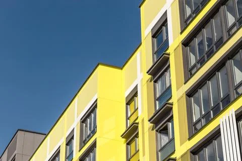 Low angle view of modern bright yellow and grey residential building facade.. Stock Photos