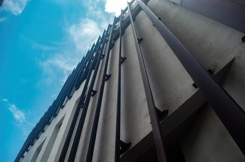 Low angle view of a modern building facade with vertical metal beams agains.. Stock Photos