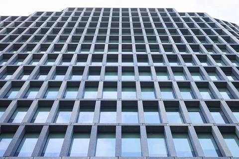 Low angle view of modern building facade with repetitive grid windows and g.. Stock Photos