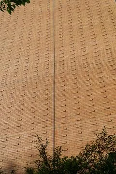 Low-angle view of a modern building's textured brick facade with staggered .. Stock Photos