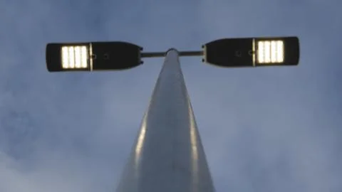 Low angle view of modern double head LED street light glowing against twiligh Fotos Stock