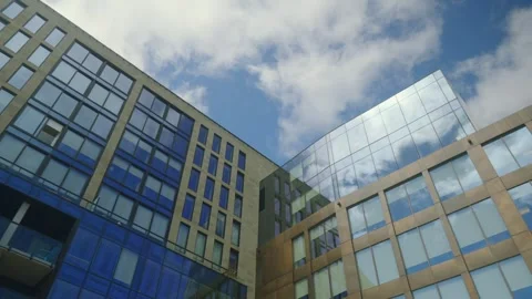 Low Angle View of Modern Glass Buildings with Blue Sky and White Clouds 4K Stock Footage 303426927
