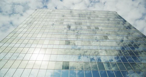 Low Angle View of Modern Glass Office Building Reflecting Sky and Clouds Stock Footage 328847245