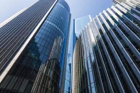 Low angle view of modern glass skyscrapers against blue sky Stock Photos