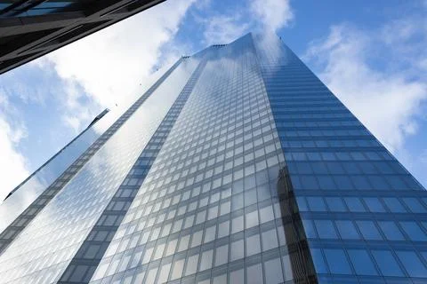 Low angle view of modern glass skyscraper against blue sky Stock-Fotos