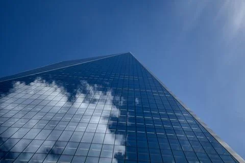 Low-angle view of a modern glass skyscraper's sharp corner rising into a cl.. Stock Photos