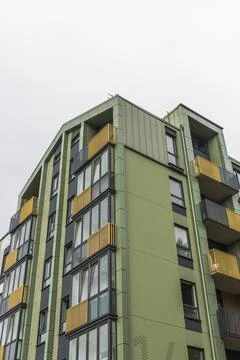 Low-angle view of a modern green apartment building corner featuring contem.. Stock Photos