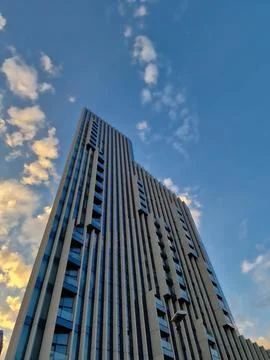 Low-Angle View of a Modern High-Rise Skyscraper Against a Sky with Clouds Stock Photos