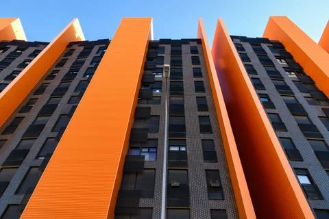 Low-angle view of a modern high-rise building with dramatic orange vertical.. Stock Photos