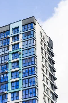 Low angle view of modern high rise residential building with blue and teal .. Stock Photos