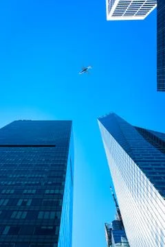 Low angle view of modern office buildings and aircraft against s Stock Photos