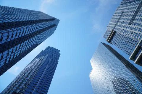 Low angle view of modern office building skyscraper with blue glass wall Stock Photos
