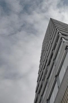 Low angle view of modern office building against cloudy sky Stock Photos