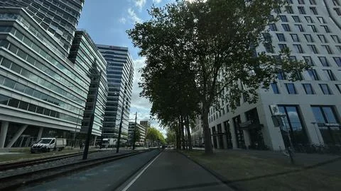 Low-angle view of modern office towers and tram lines above city street under Stock Photos