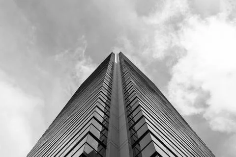 Low angle view of a modern skyscraper corner with blue cloudy sky at background Stock Photos