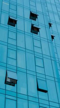 Low angle view of modern skyscraper blue glass building facade with several o Stock Photos