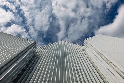 Low angle view of modern white facade buildings against dramatic cloudy sky.. Stock Photos