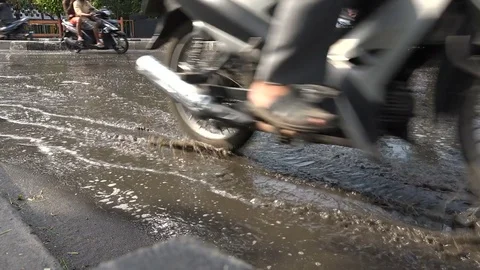 Low angle view motorcycles and other traffic on flooded road Surabaya, Indonesia Video stock 78570206