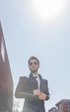 Low angle view, one young man buttoning suit, sky day Sun Foto stock
