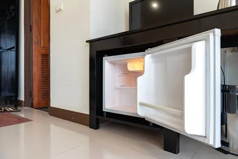 Low angle view of the opened mini fridge with water bottles placed under wo.. 스톡 사진