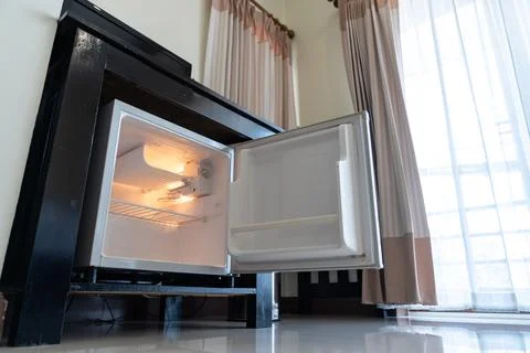 Low angle view of the opened mini fridge with water bottles placed under wo.. Foto stock