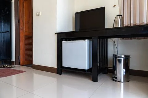 Low angle view of the opened mini fridge with water bottles placed under wo.. Foto stock