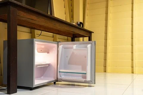 Low angle view of the opened mini fridge with water bottles placed under wo.. Foto stock