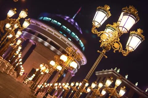 Low angle view of ornate glowing street lamps at night in the city center of  Foto stock