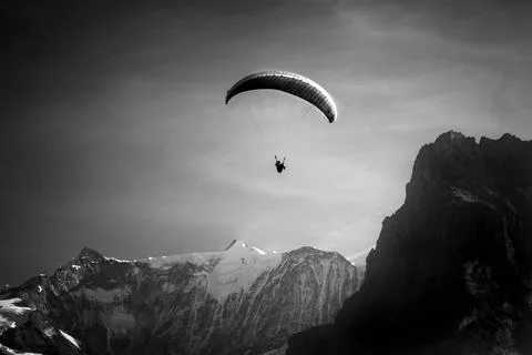 Low angle view of paraglider against snowcapped mountain range Stock Photos