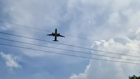 Low Angle View of Passenger Airplane Descending for Landing Against Blue Stock Footage 332415457