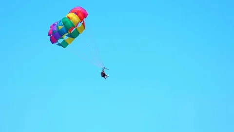 Low angle view of people parasailing against clear blue sky, tourists enjoying Stock Footage 128849745